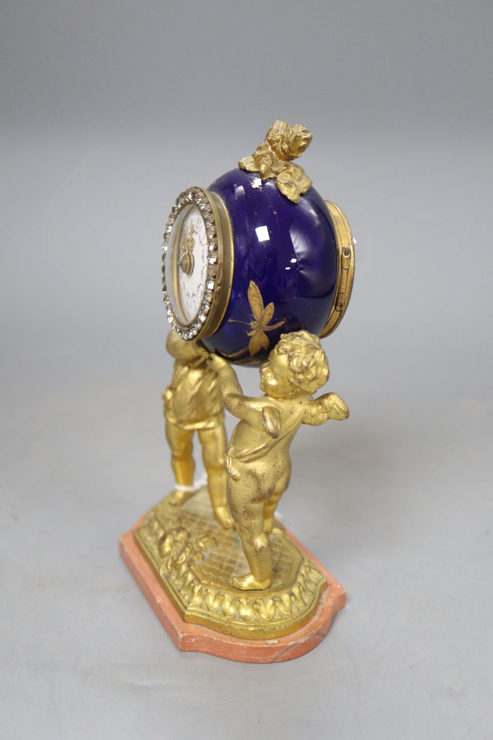 A French gilt metal and enamel cherub timepiece, height 18.5cm